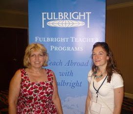 Sallie Hunter and friend in front of Fulbright banner